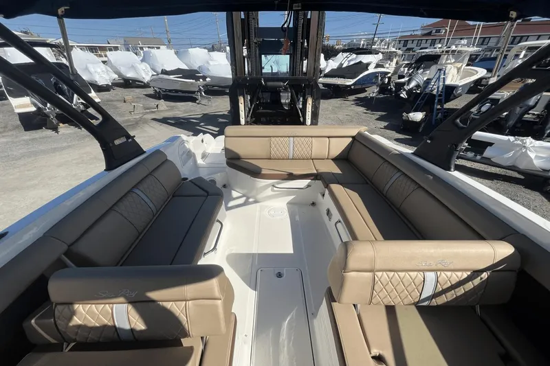 Slide: The Image of 2017 Sea Ray 270SDX boat interior with tan seating, docked in a marina. - 13