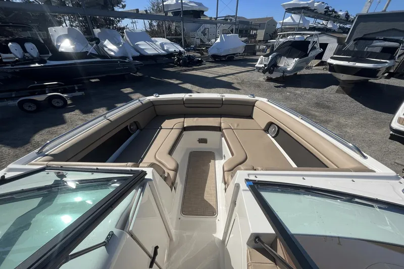 Slide: The Image of 2017 Sea Ray 270SDX boat interior with tan seating, docked among other boats. - 21