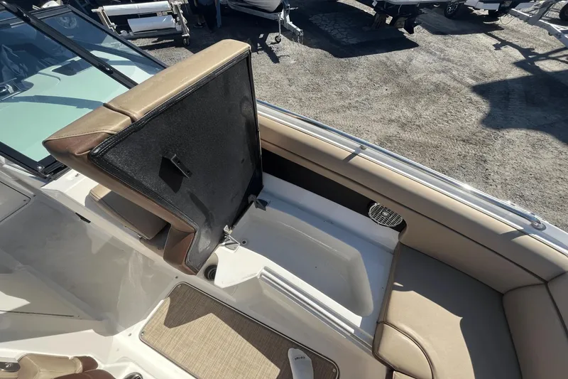 Slide: The Image of 2017 Sea Ray 270SDX boat interior with open storage compartment and beige seating. - 23