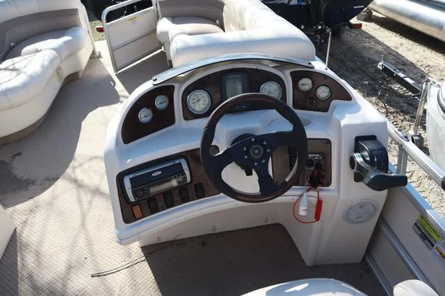 Slide: The Image of 2005 Godfrey Aqua Patio 220 RE boat dashboard with steering wheel and control panel. - 10