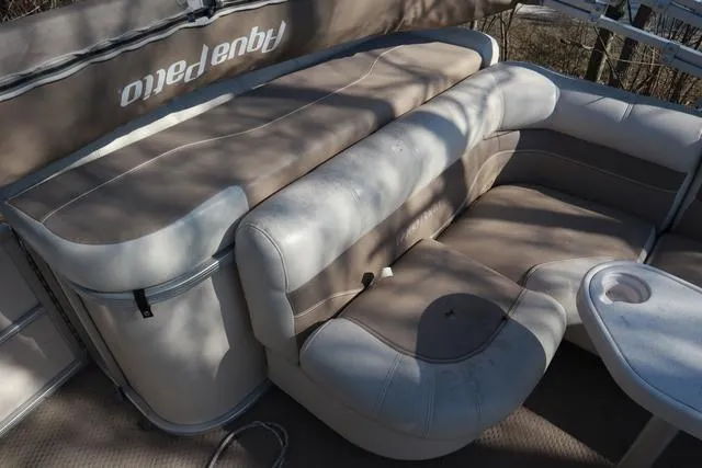 Slide: The Image of 2005 Godfrey Aqua Patio 220 RE boat interior with beige seating and table. - 11