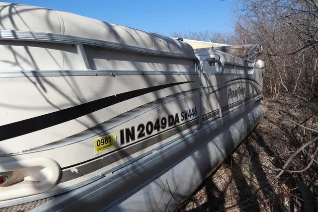 Slide: The Image of 2005 Godfrey Aqua Patio 220 RE pontoon boat, parked on land, surrounded by trees. - 13