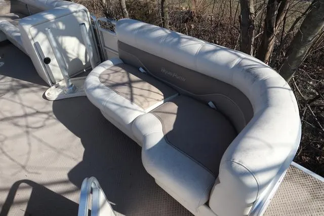 Slide: The Image of 2005 Godfrey Aqua Patio 220 RE boat seating area with cushioned bench and neutral tones. - 4
