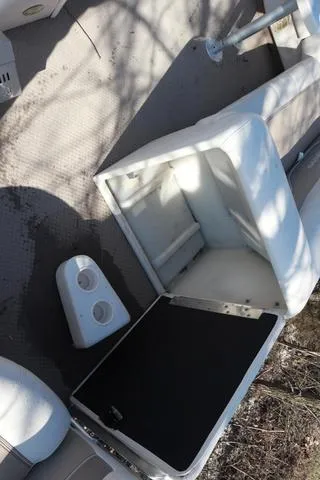 Slide: The Image of 2005 Godfrey Aqua Patio 220 RE boat interior with open storage compartment and cup holders. - 6