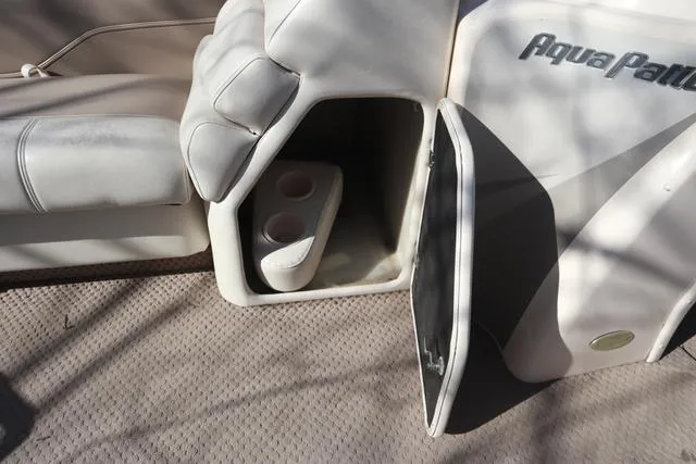 Slide: The Image of 2005 Godfrey Aqua Patio 220 RE boat interior with open storage compartment and cup holders. - 7