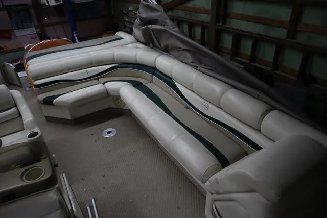 Slide: The Image of 2002 Bennington 2275 FSI boat interior with beige and green seating in storage. - 10