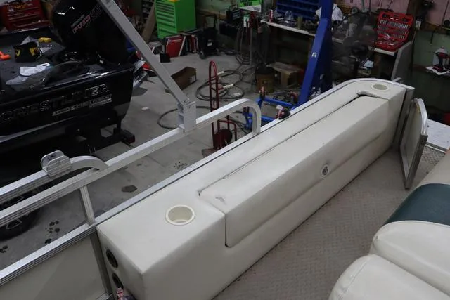Slide: The Image of 2002 Bennington 2275 FSI boat interior with white seating in a workshop setting. - 13