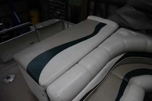 Slide: The Image of 2002 Bennington 2275 FSI boat interior with white and green cushioned seating. - 15