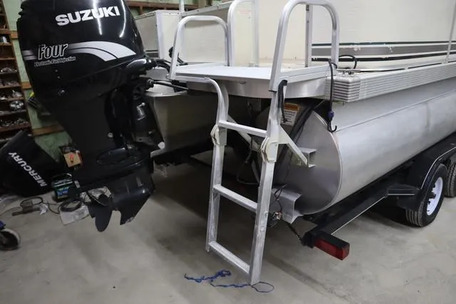 Slide: The Image of 2002 Bennington 2275 FSI pontoon boat with Suzuki outboard motor and ladder in a garage. - 16