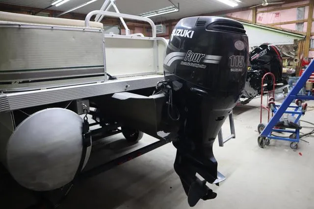 Slide: The Image of 2002 Bennington 2275 FSI pontoon boat with Suzuki 115 outboard motor in a workshop. - 5
