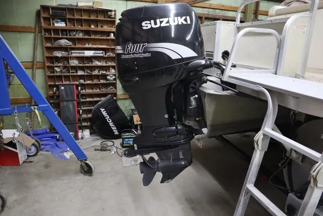 Slide: The Image of Suzuki outboard motor on a 2002 Bennington 2275 FSI pontoon boat in a garage. - 6