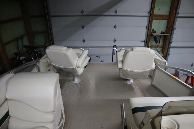 Slide: The Image of Interior of a 2002 Bennington 2275 FSI boat with white seating in a garage. - 7