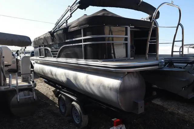 Slide: The Image of 2020 Lowe SS 210 V pontoon boat on trailer, black canopy, parked outdoors. - 3