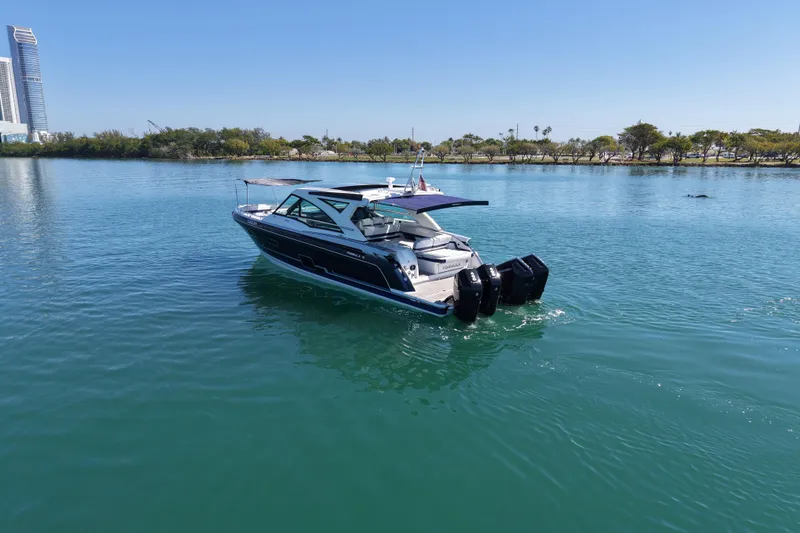Slide: The Image of 2024 Formula 430 SSC boat cruising on a calm, scenic waterway. - 2