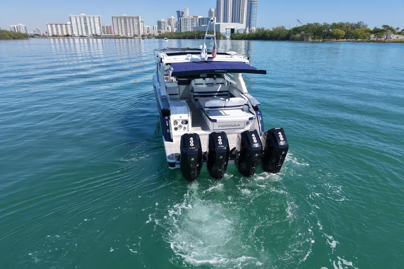Slide: The Image of 2024 Formula 430 SSC boat cruising on a calm waterway with city skyline in background. - 5