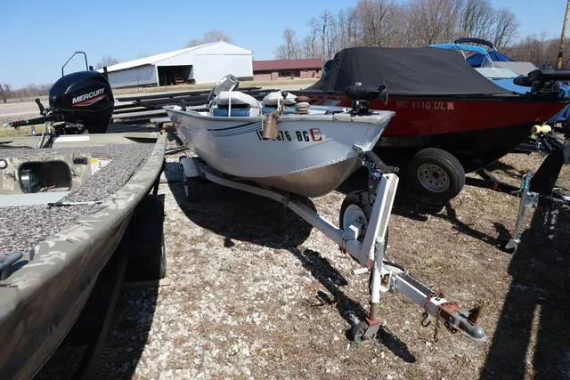 Slide: The Image of Grumman GV1465 boat from 1996 on trailer, surrounded by other boats and equipment. - 7