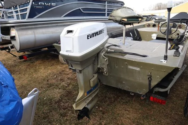 Slide: The Image of 1984 Monark 1648 SC boat with Evinrude outboard motor, parked on grass. - 3