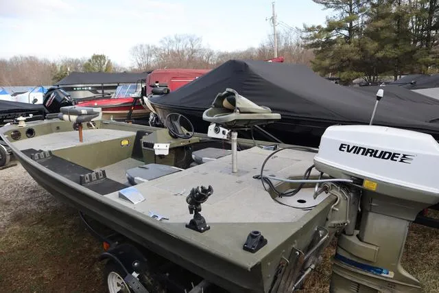 Slide: The Image of 1984 Monark 1648 SC boat with Evinrude motor, parked outdoors. - 4