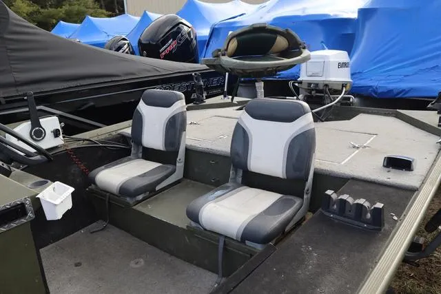 Slide: The Image of 1984 Monark 1648 SC boat interior with dual seats and motor, docked outdoors. - 6