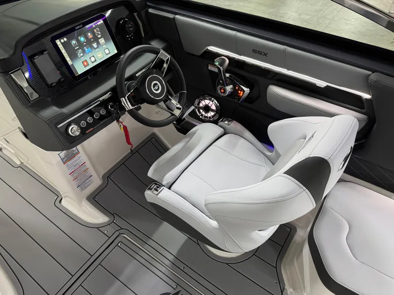 Slide: The Image of 2025 Chaparral 2870 SSX boat cockpit with modern steering, touchscreen display, and sleek white seating. - 15