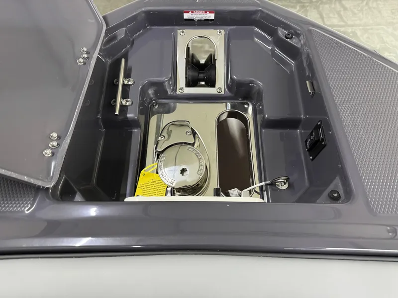 Slide: The Image of 2025 Chaparral 2870 SSX boat anchor compartment with stainless steel fittings and open hatch. - 37