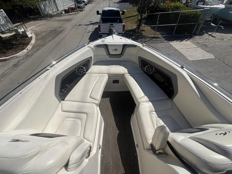 Slide: The Image of 2014 Monterey 328 Super Sport boat with white seating and speakers, parked on a street. - 18