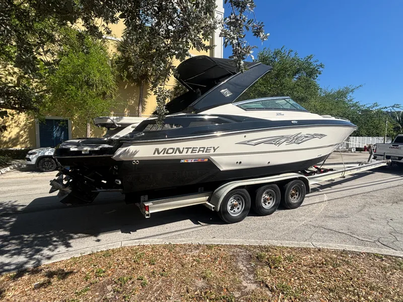 Slide: The Image of 2014 Monterey 328 Super Sport boat on a trailer, parked outdoors. - 2