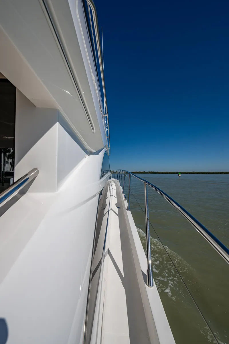 Slide: The Image of Side view of 2016 Princess Flybridge 64 Motor Yacht on calm water under clear blue sky. - 22