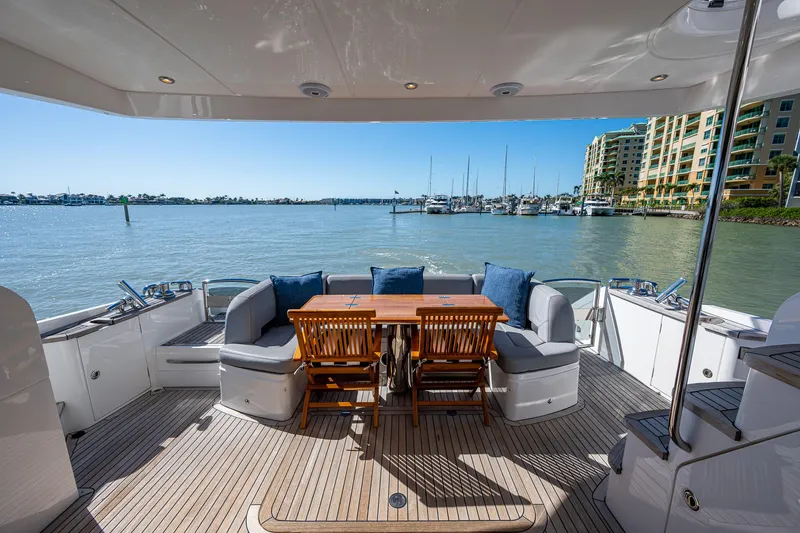Slide: The Image of Luxurious 2016 Princess Flybridge 64 Motor Yacht deck with seating and scenic marina view. - 24