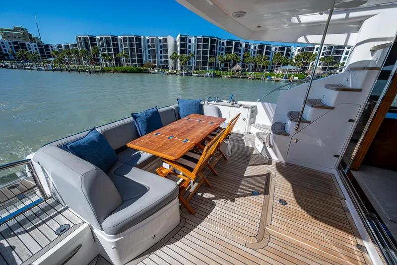 Slide: The Image of Luxurious 2016 Princess Flybridge 64 Motor Yacht with elegant outdoor seating and scenic waterfront view. - 25