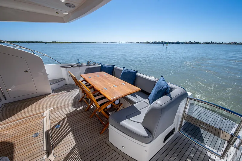 Slide: The Image of Luxurious 2016 Princess Flybridge 64 Motor Yacht deck with seating and ocean view. - 26