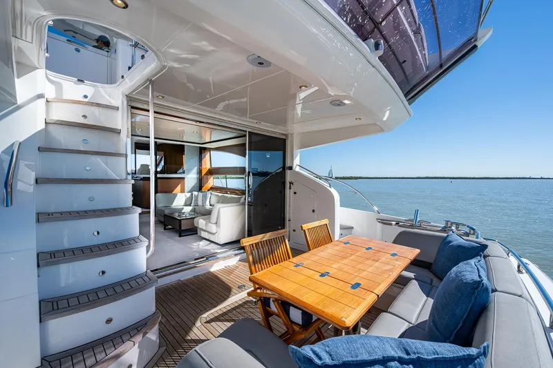 Slide: The Image of Luxurious 2016 Princess Flybridge 64 Motor Yacht with elegant outdoor seating and scenic water view. - 28