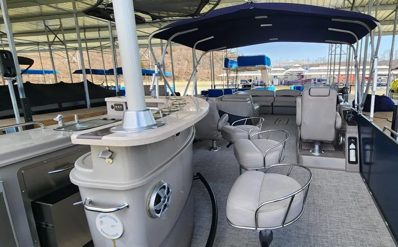 Slide: The Image of 2016 Premier 290 Grand Entertainer pontoon boat interior with seating and bar area. - 10