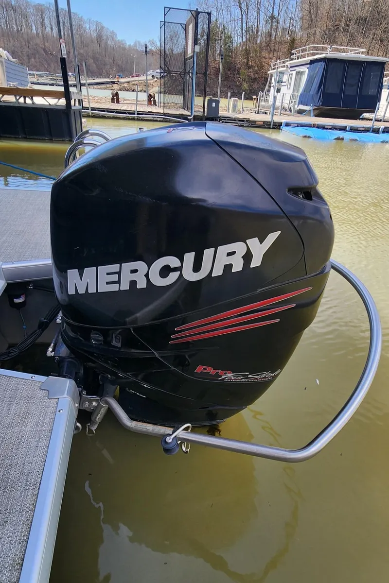 Slide: The Image of Mercury outboard motor on 2016 Premier 290 Grand Entertainer boat, docked in calm water. - 14