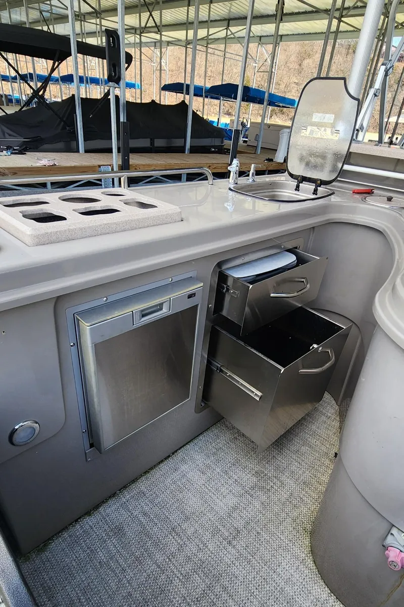 Slide: The Image of 2016 Premier 290 Grand Entertainer boat interior with storage drawers and appliances. - 16