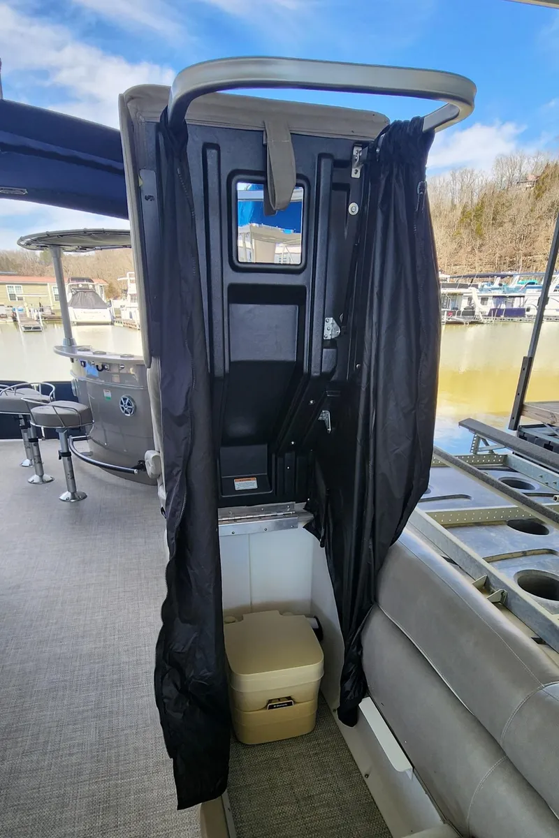 Slide: The Image of 2016 Premier 290 Grand Entertainer boat interior with privacy curtain and seating area. - 17