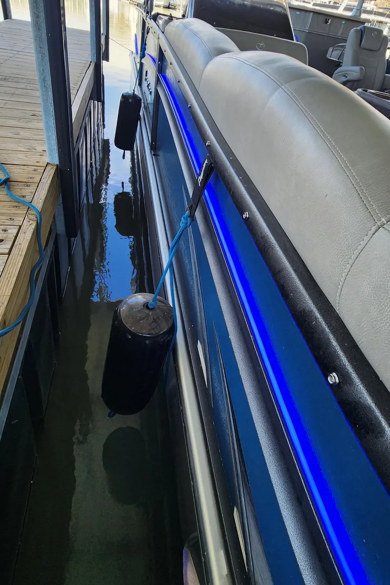 Slide: The Image of 2016 Premier 290 Grand Entertainer pontoon boat docked with blue LED lights. - 22