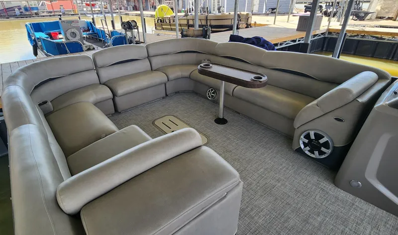 Slide: The Image of 2016 Premier 290 Grand Entertainer pontoon boat interior with plush seating and table. - 3