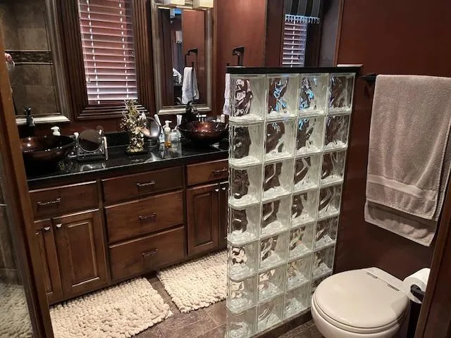 Slide: The Image of Luxurious houseboat bathroom with glass block divider, wooden cabinets, and modern fixtures. - 19