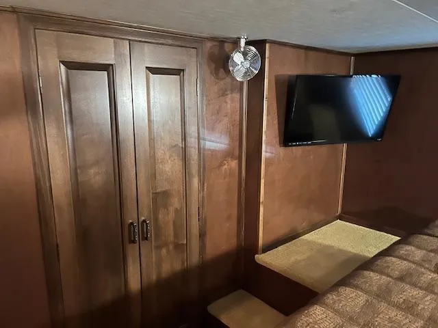 Slide: The Image of Interior of 2013 Thoroughbred houseboat with wooden cabinets and mounted TV. - 34