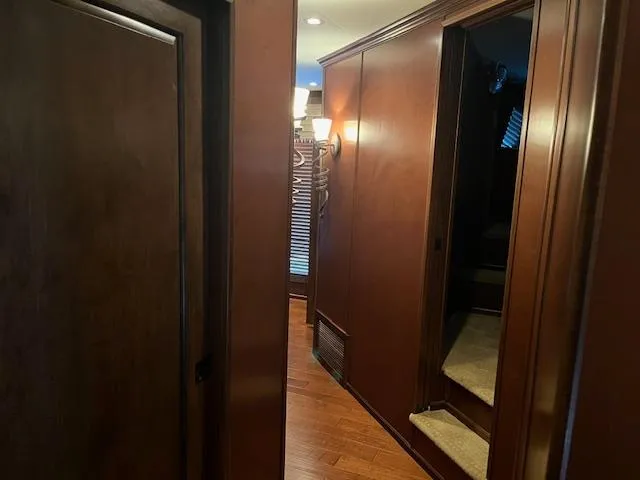 Slide: The Image of Interior hallway of a 2013 Thoroughbred houseboat with wooden paneling and carpeted stairs. - 43