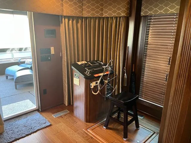 Slide: The Image of 2013 Thoroughbred houseboat interior with steering wheel, wooden flooring, and outdoor seating area. - 7