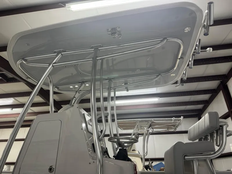 Slide: The Image of 2025 Contender 25 Tournament boat with T-top and seating in a storage facility. - 9