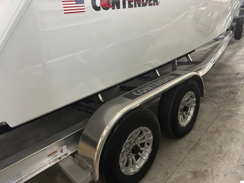 Slide: The Image of 2025 Contender 25 Tournament boat on trailer, featuring dual axles and sleek design. - 23