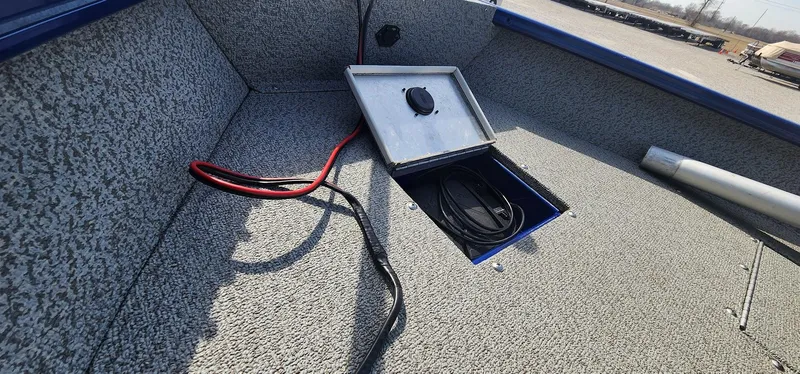 Slide: The Image of 2016 Tracker Pro Guide V-16 WT boat interior with open storage compartment and cables. - 12