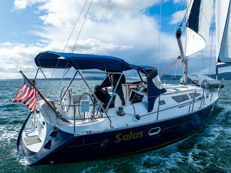 Slide: The Image of Jeanneau Sun Odyssey 40 sailboat from 2001 sailing on open water with American flag. - 14