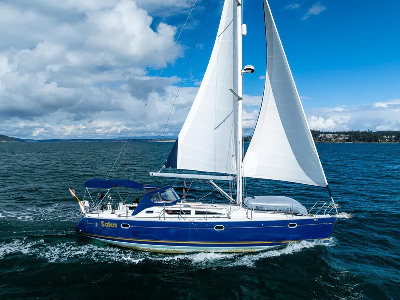 Slide: The Image of 2001 Jeanneau Sun Odyssey 40 sailing on open water under a clear blue sky. - 17