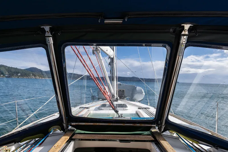 Slide: The Image of View from Jeanneau Sun Odyssey 40 sailboat cockpit, overlooking serene ocean and distant hills. - 18