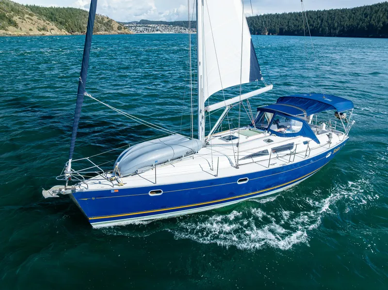 Slide: The Image of 2001 Jeanneau Sun Odyssey 40 sailing on open water, blue hull, white sails, scenic background. - 2