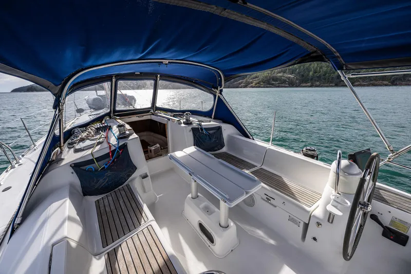 Slide: The Image of 2001 Jeanneau Sun Odyssey 40 sailboat cockpit with blue canopy, steering wheel, and seating area. - 26